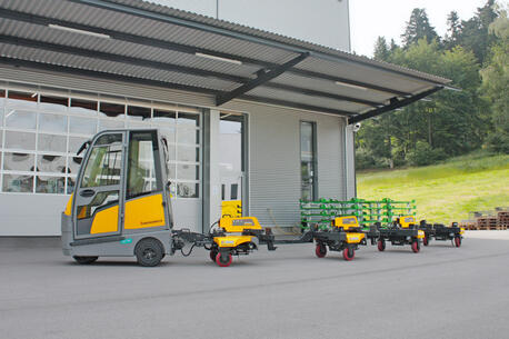 INDUSTRY TRAIN Routenzug Baureihe IT500 für den Indoor-Einsatz mit C-Rahmen Warenträgern. Zugfahrzeug Jungheinrich Elektro-Schlepper EZS 570.