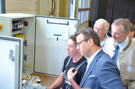 Minister Hauk listens to the trainees explaining the apprentices’ line inspection training project.