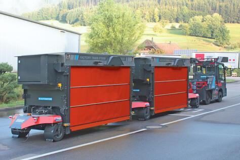 Outdoor AGV: Factory Train FT600 automated outdoor tugger train in outdoor use.